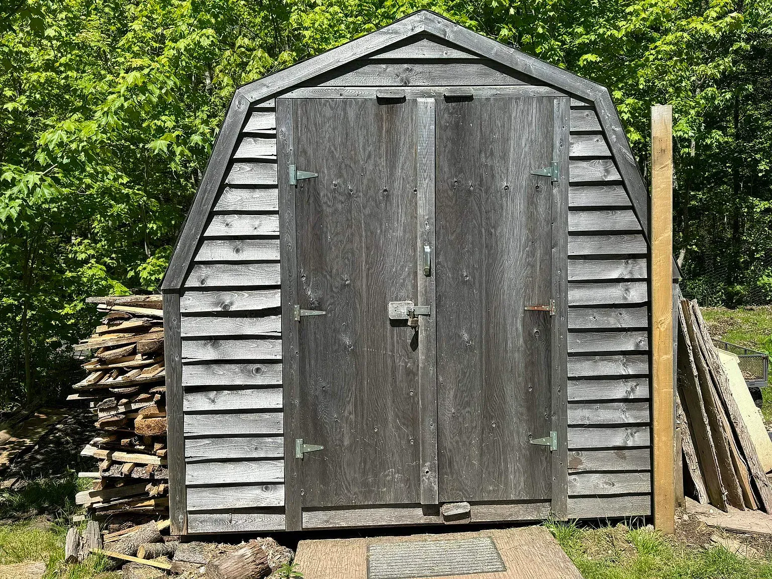 Here’s the A-frame shed — weathered boards, simple joinery. An older lady built this. Respect.