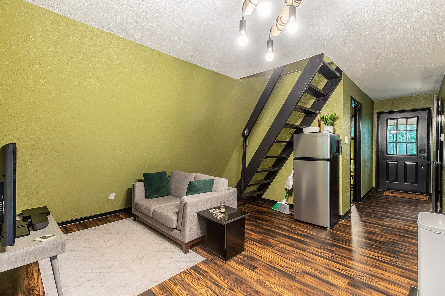 Living room greens plus a gray sofa. Here's where she reads.