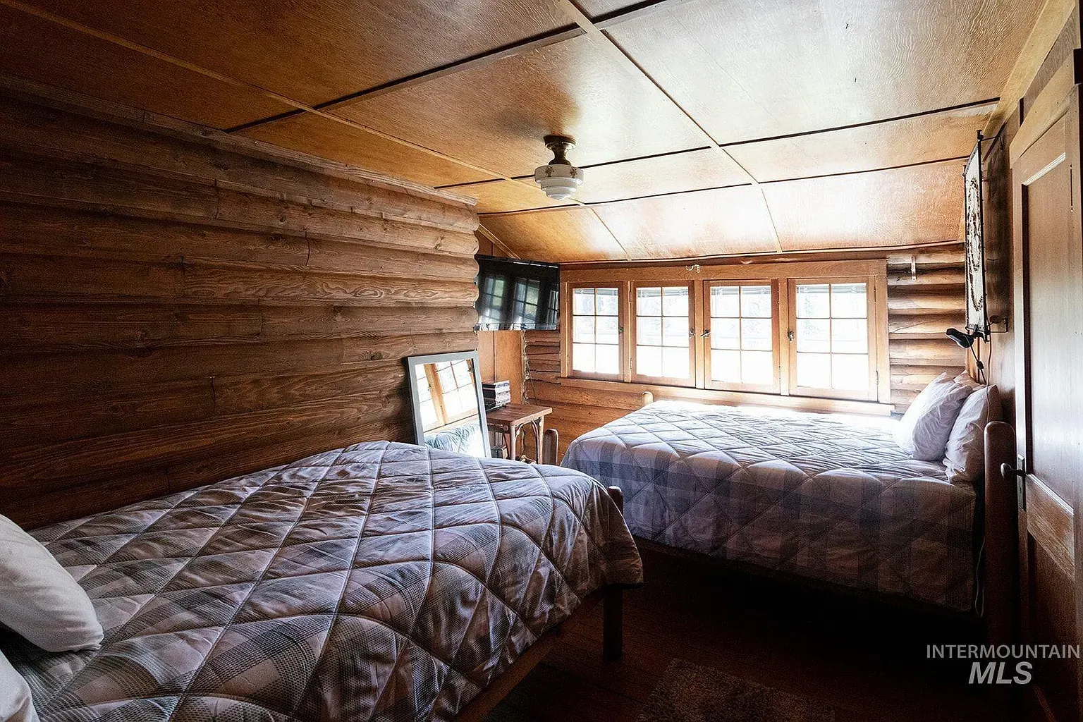 ## Honey-toned logs radiate heat; a pale wood ceiling floats above, calm and bright.