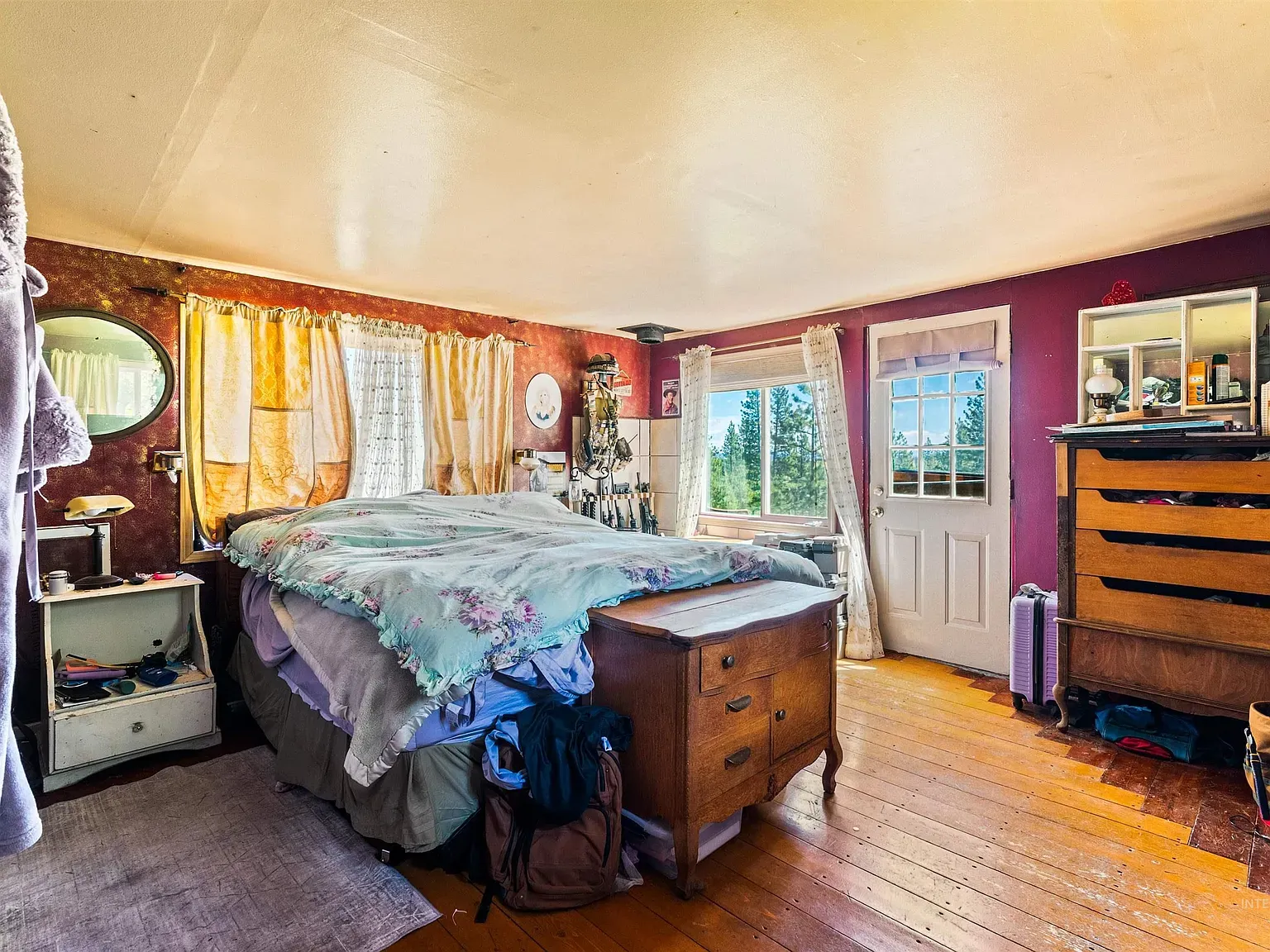 Large bed with a floral duvet, warm wood around.