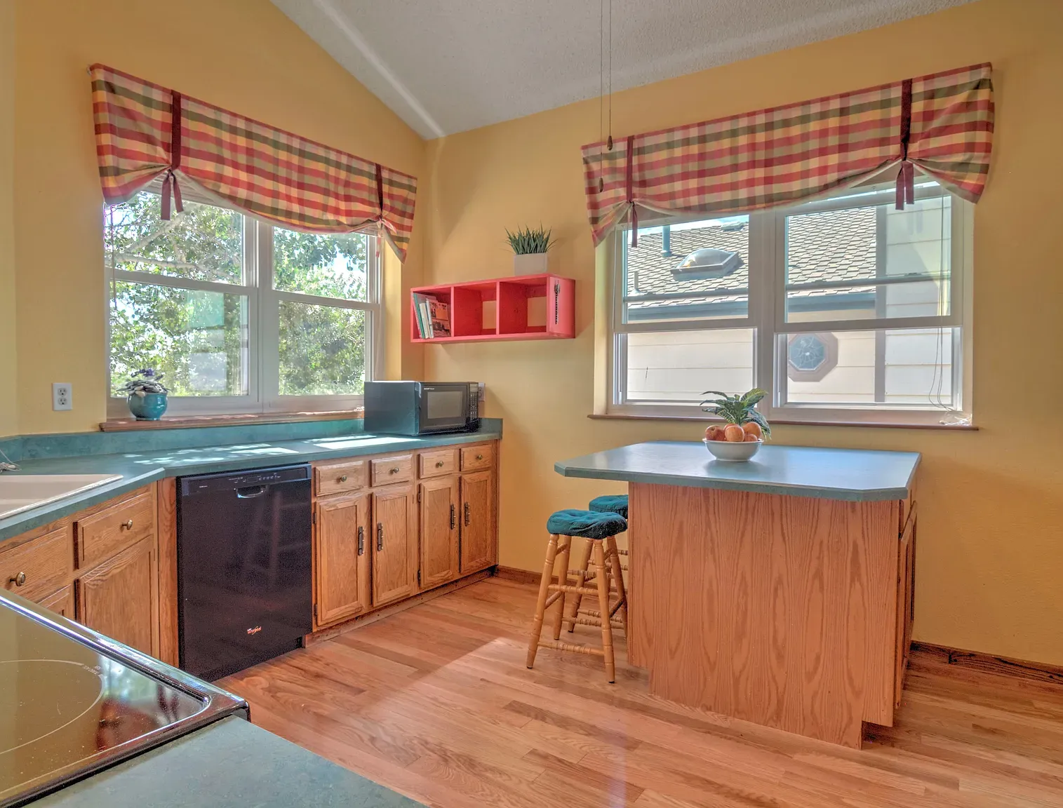 Sunshine-yellow kitchen with plaid valances. This place is surprisingly colorful, in a good way.