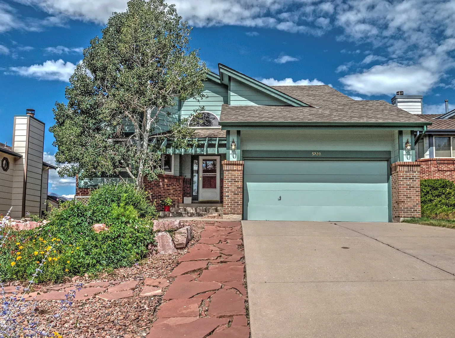Here’s the front — pastel blue with brick. The arched entry is sweet.