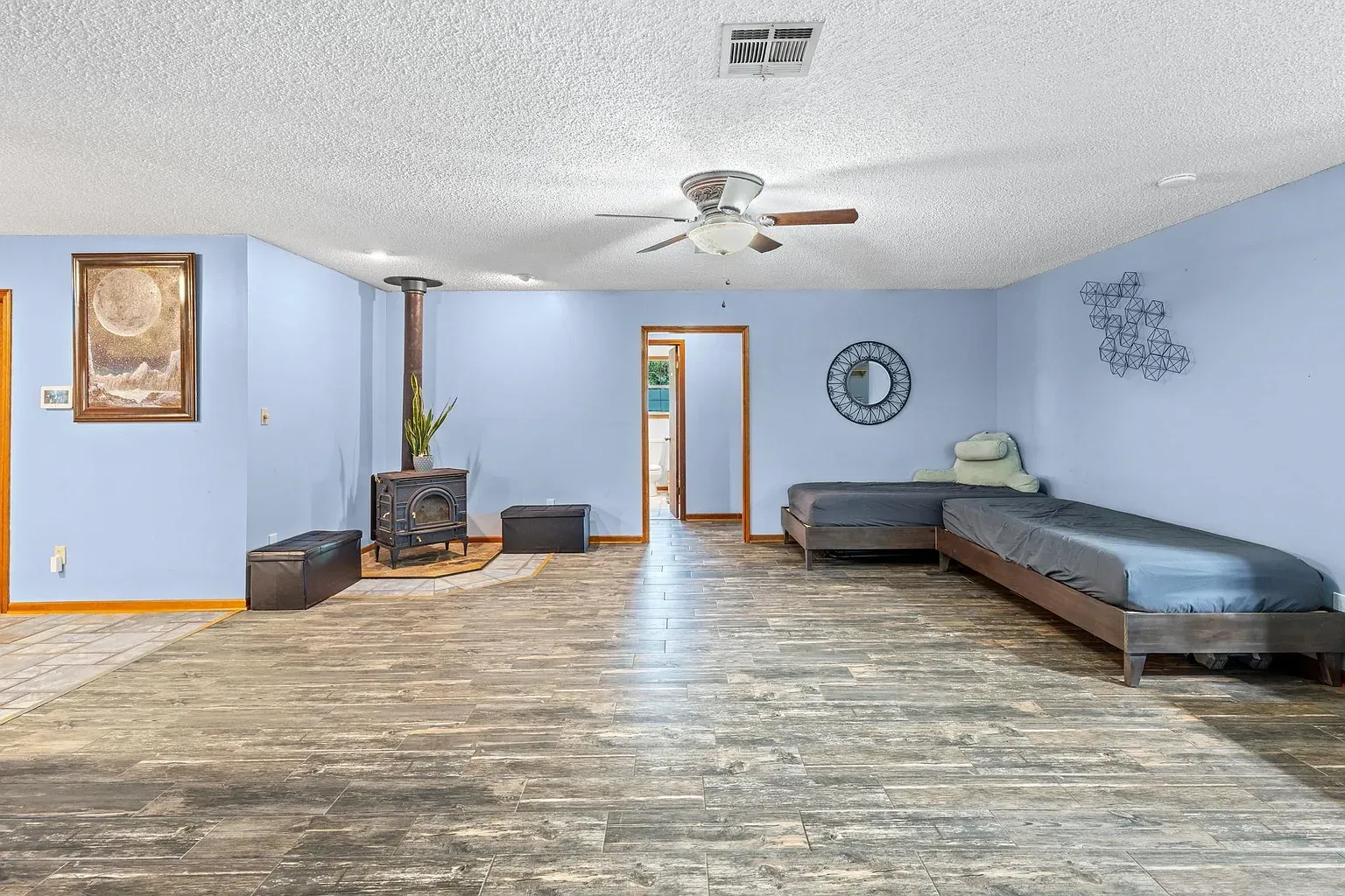 Big bonus room? Light blue, textured ceiling, dark wood-look tile floors.
