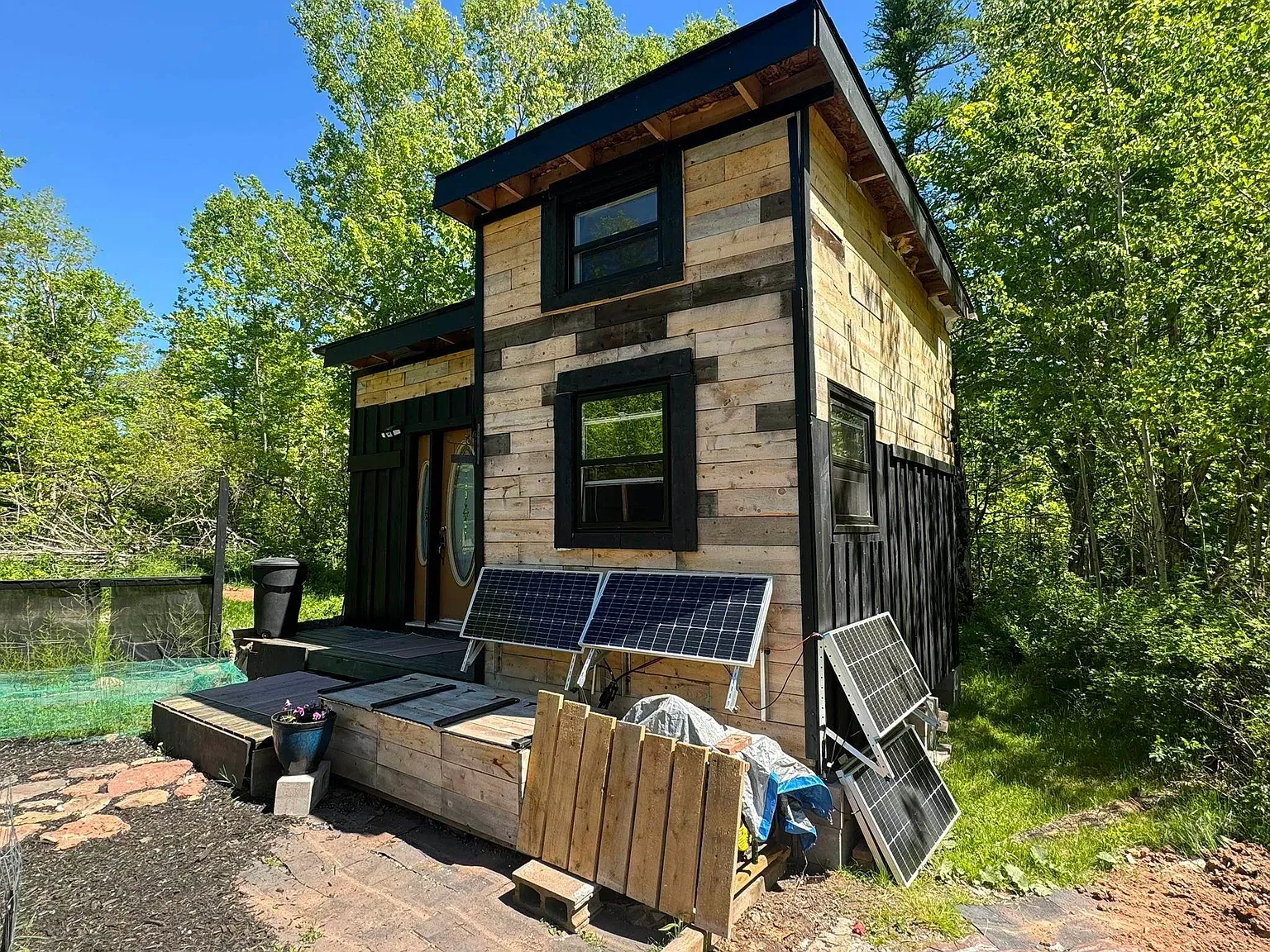 Here’s the exterior — warm wood planks, modern lines, forest hug. She built this?