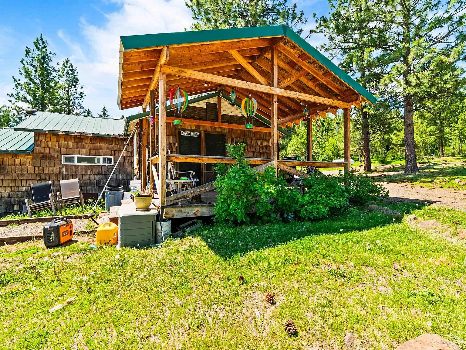 Wood siding in mixed tones, green metal roof above.