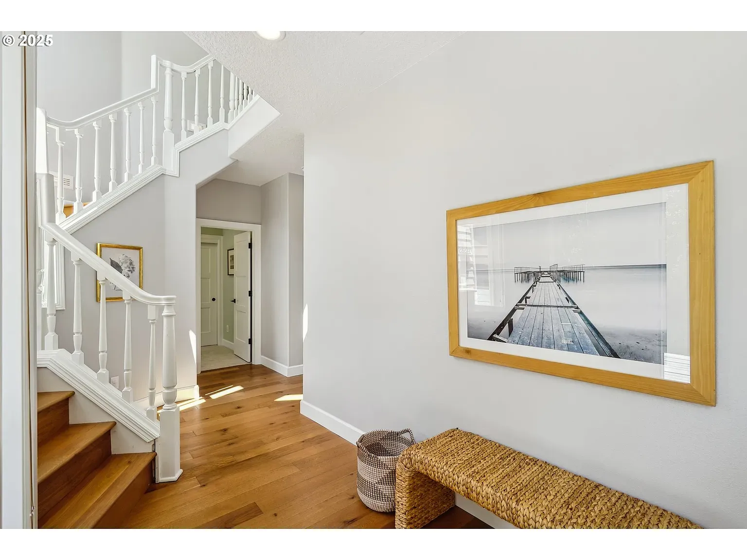 Entryway stays airy — soft gray, warm floors, light everywhere. Feels welcoming.