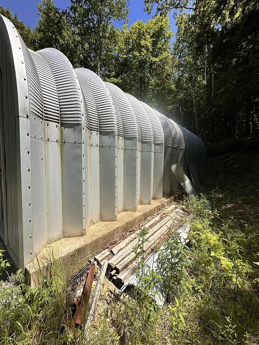 Back outside — corrugated arc again, very streamlined. Airplane hangar meets cabin energy.