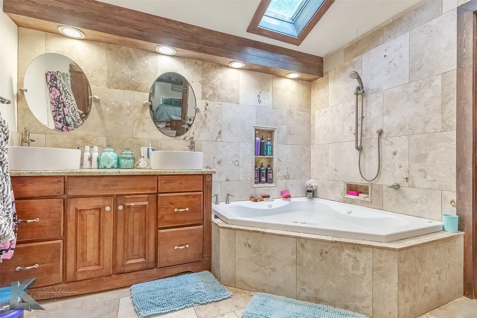 Bathroom goes spa mode—stone everywhere, dark wood ceiling. Feels expensive.