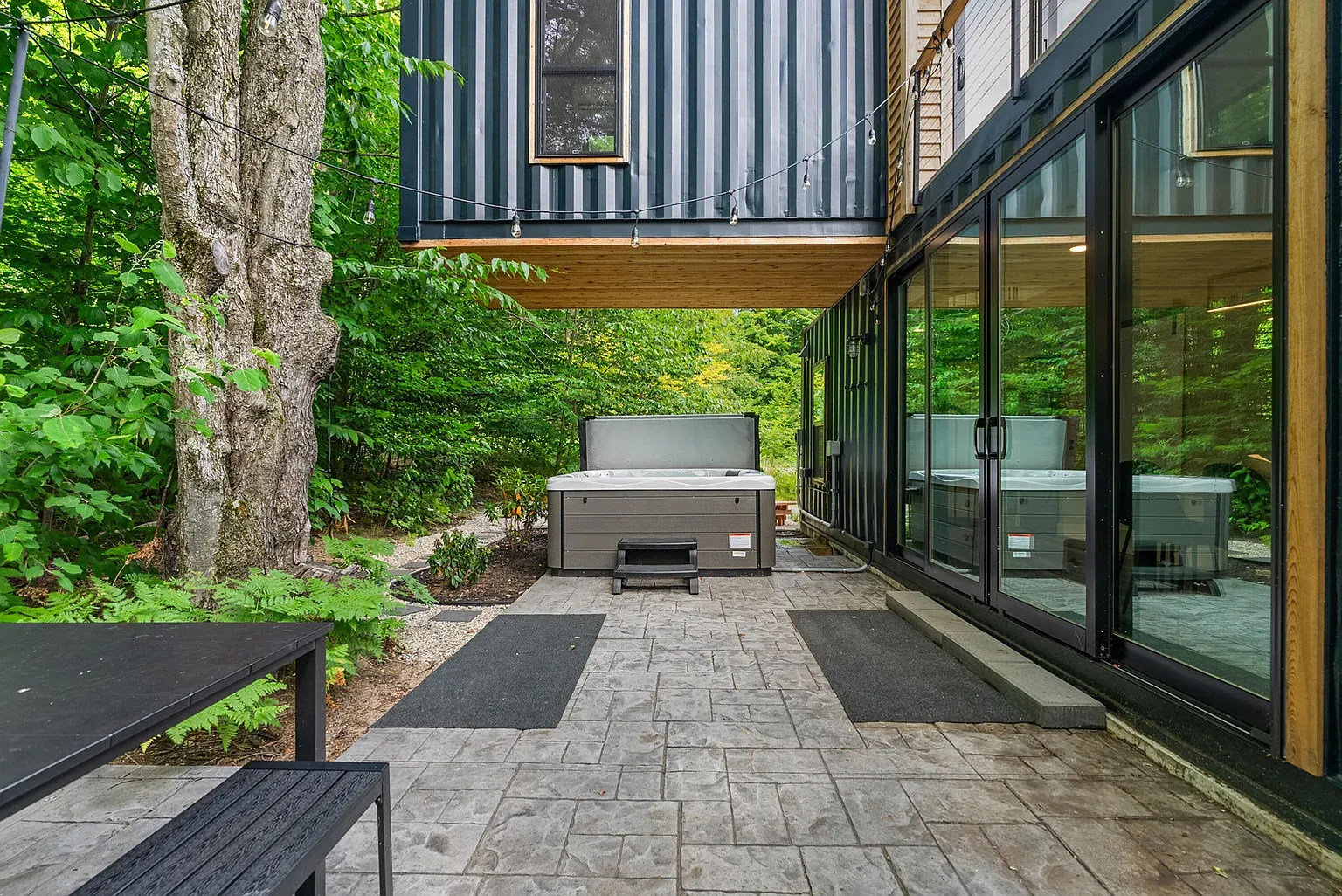 And then a hot tub patio. Steam in the trees — private retreat vibes.