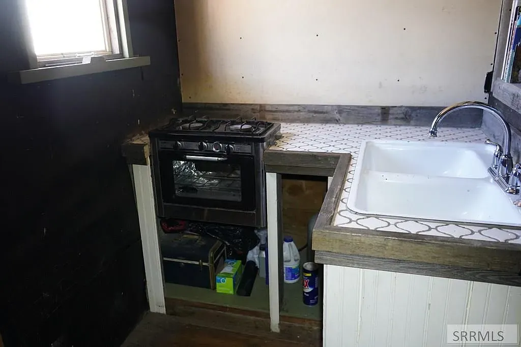 'Here’s the old kitchen space! You can see the original stove and a nice big sink—definitely has that vintage charm going on.'