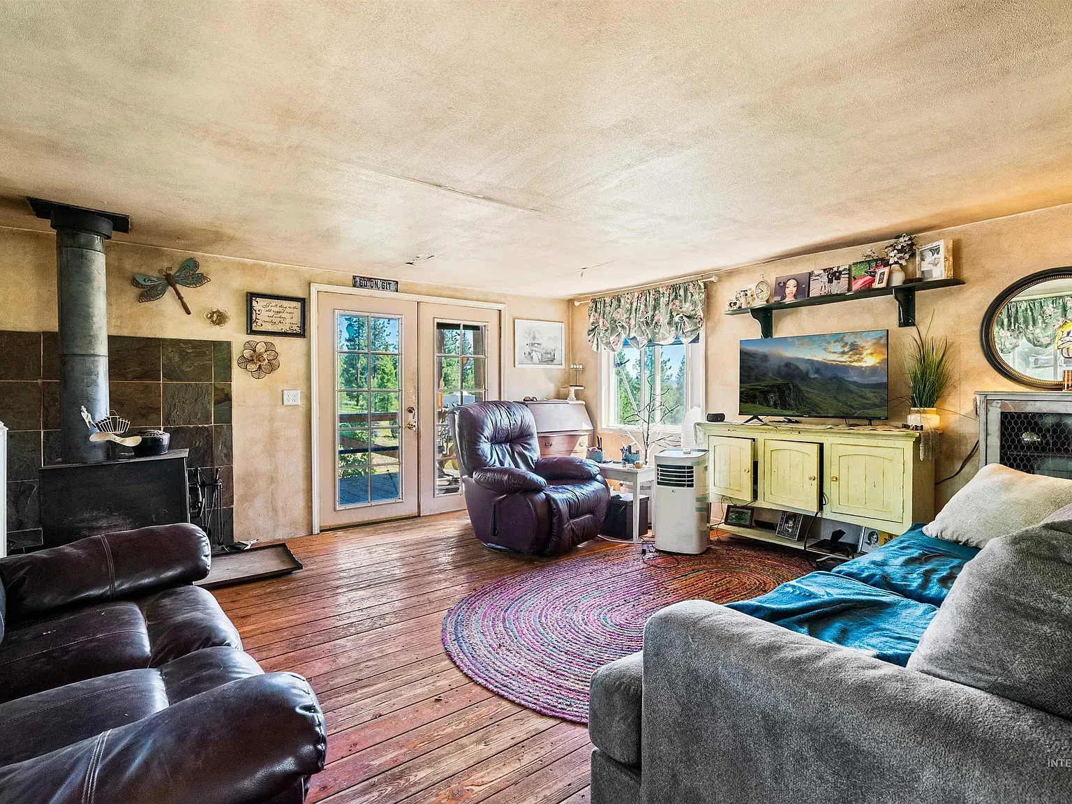Wood stove against dark brick, soft earthy walls around.