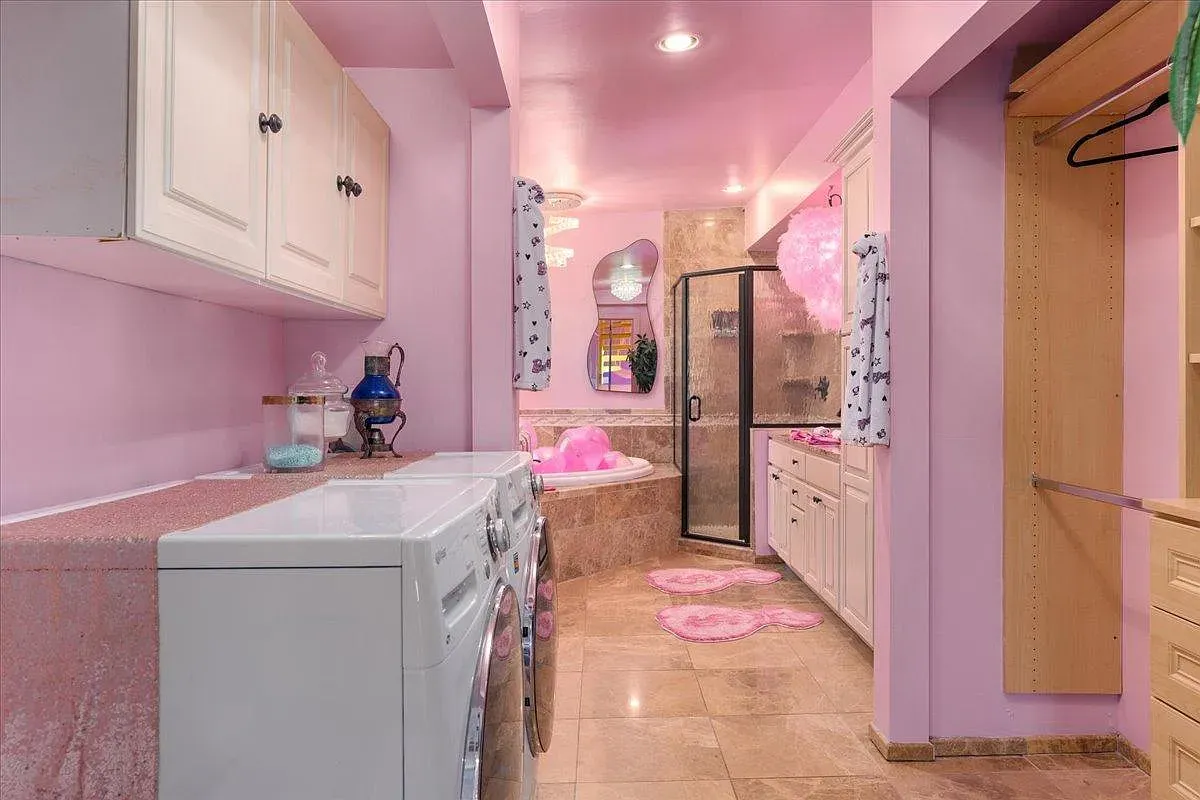 ## Laundry meets bath in pastel pink; practical layout, cute fixtures, and plenty of folding space make chores feel less like work.