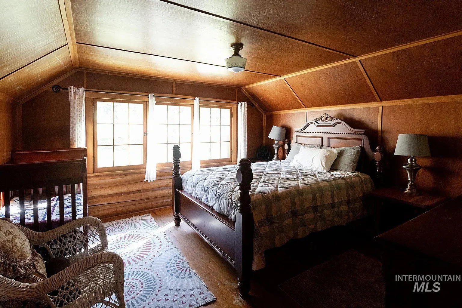 ## Wood paneling wraps around; a sloped ceiling leans in, and that ceiling-fan glow softens every edge.
