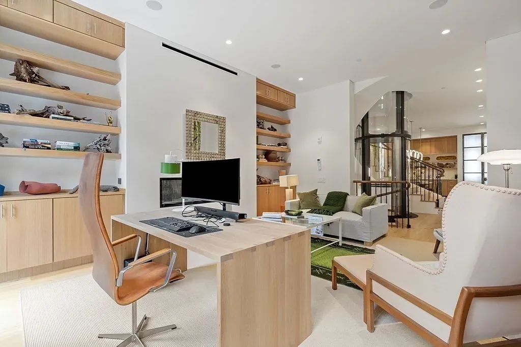 'Here’s the home office, which has a really nice open feel thanks to all the natural light. Love those built-in shelves for easy organization, plus the modern staircase adds a unique touch!'