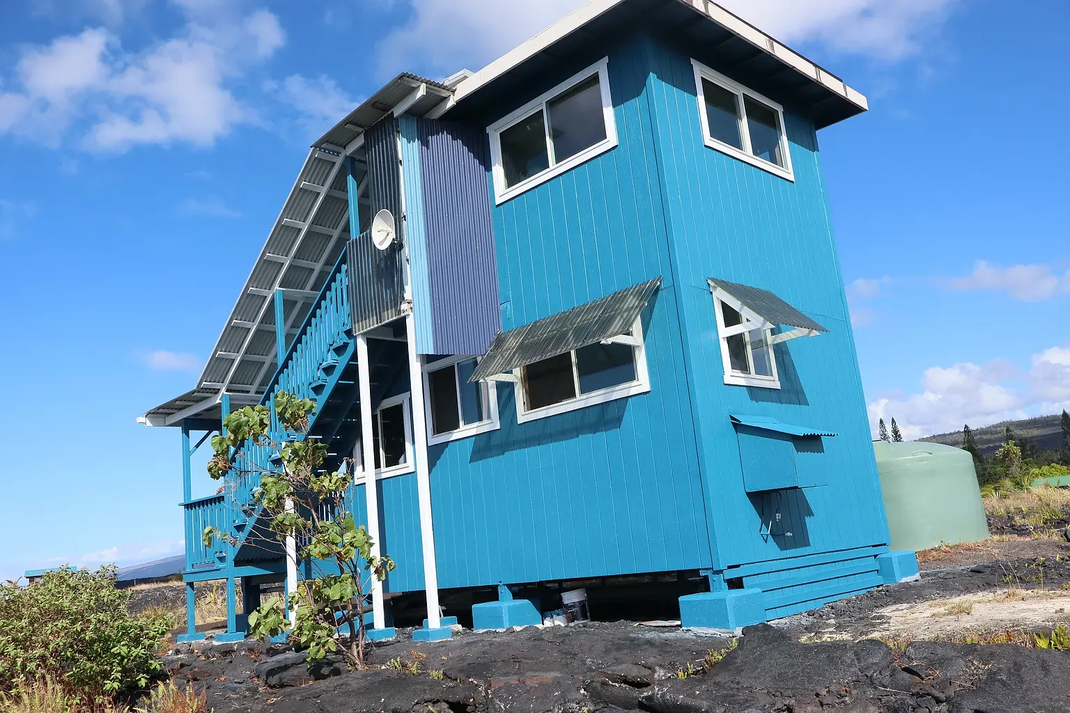 Different angle. steep roof, big windows, that ocean-blue paint still pops.