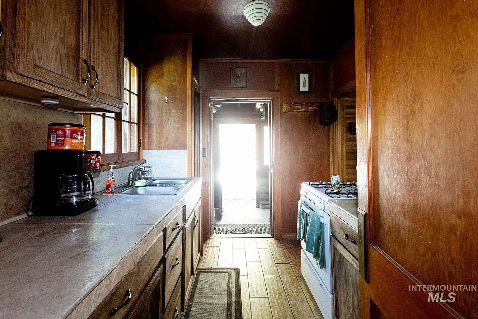 ## Dark, handsome paneling surrounds warm cabinetry; light countertops pop like fresh snowfall against the timber.