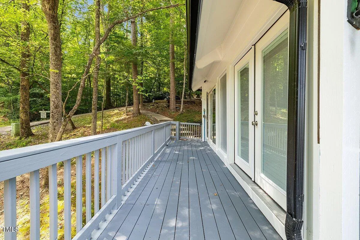 ## The elongated gray balcony feels peaceful; simple railings keep eyes on the green canopy, and the breeze kind of steals the show