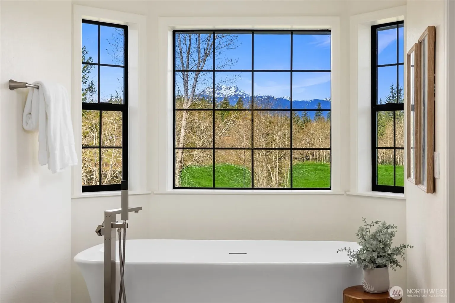 Freestanding tub, black-framed windows — feels a magazine cover.