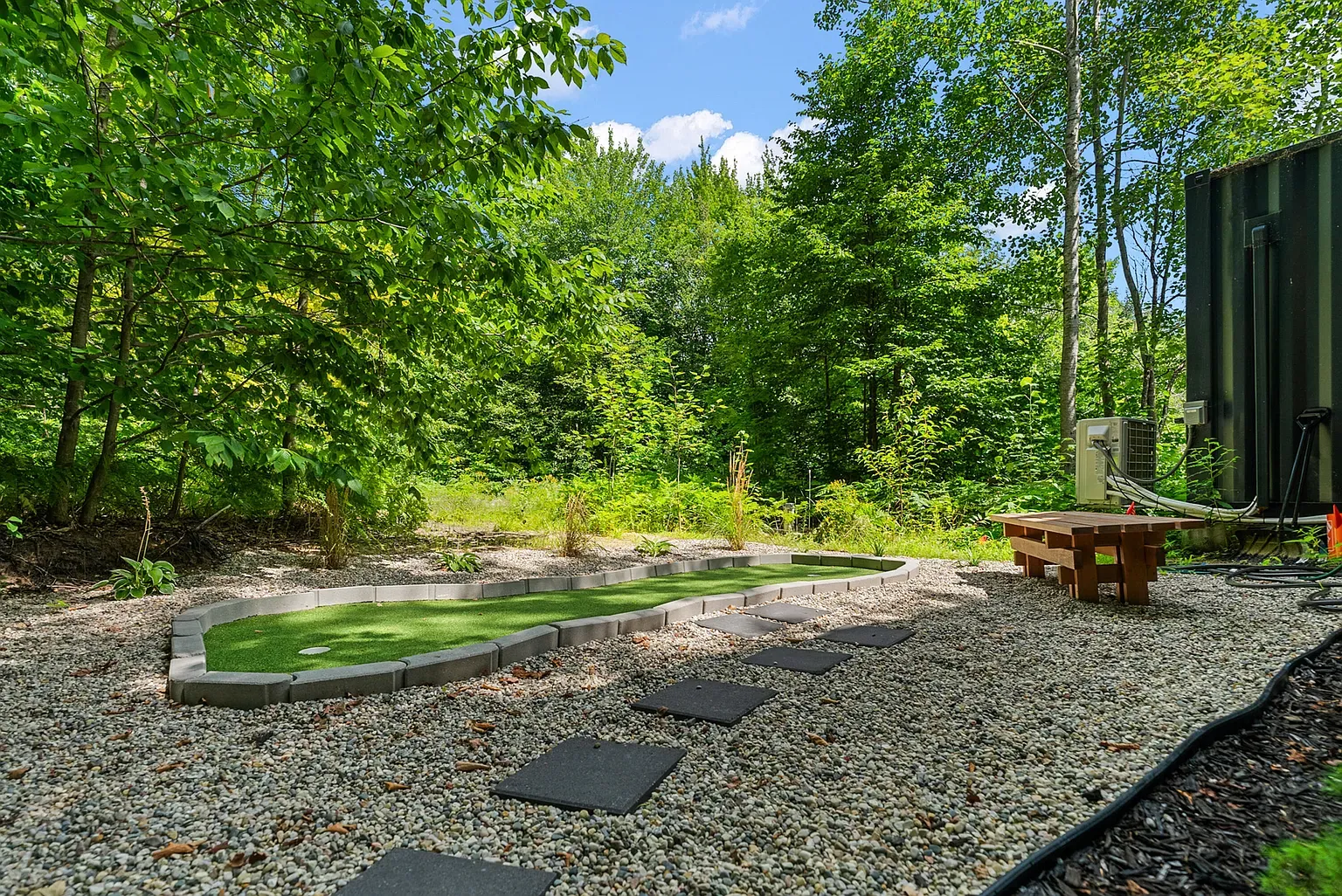 Mini-golf lane in the woods. Quiet little flex. kinda love that privacy.