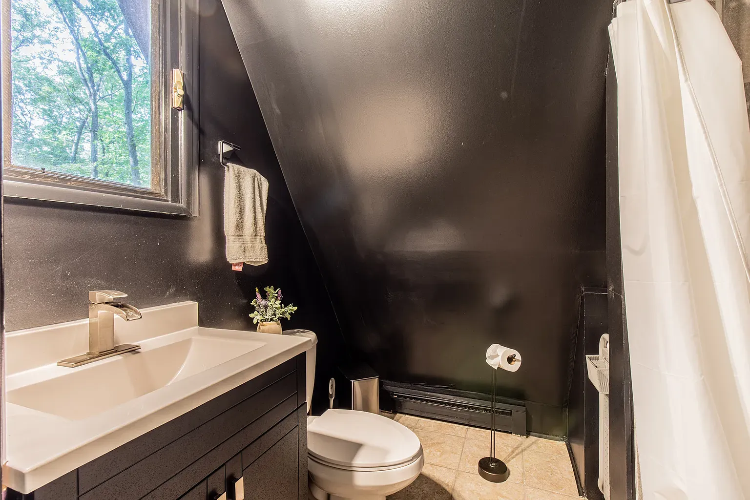Black bathroom with beige floor. I mean, it's cool, maybe intense.