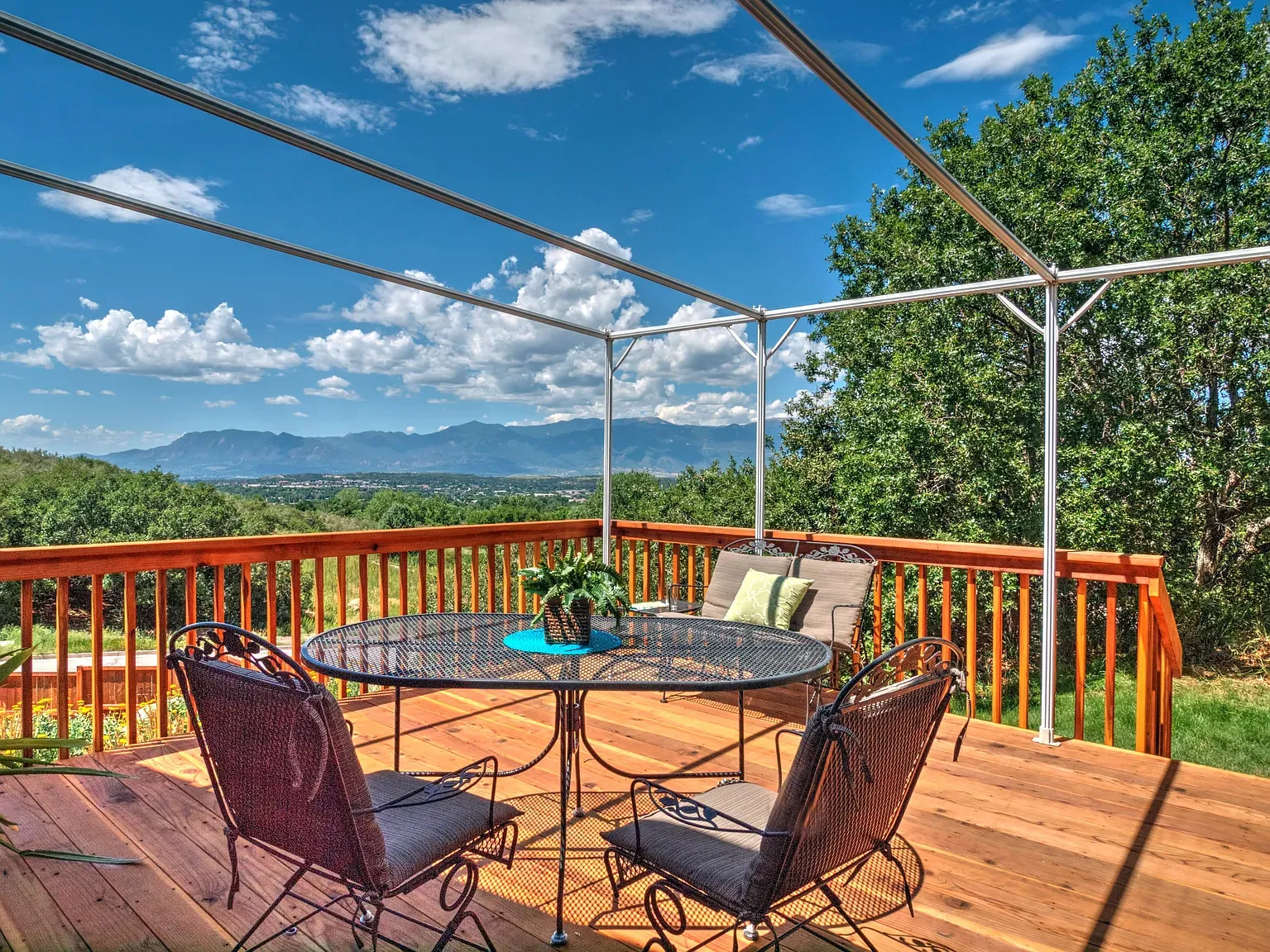 Back outside — big wooden deck with rails and a cozy center seating spot.