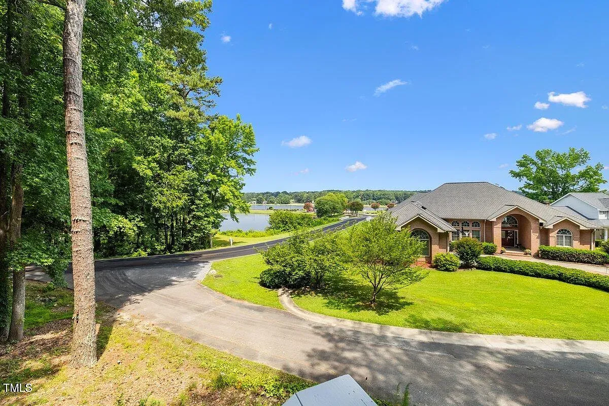 ## Down the gentle curve, manicured lawns and tall trees frame a suburban-meets-nature scene that sets a welcoming mood