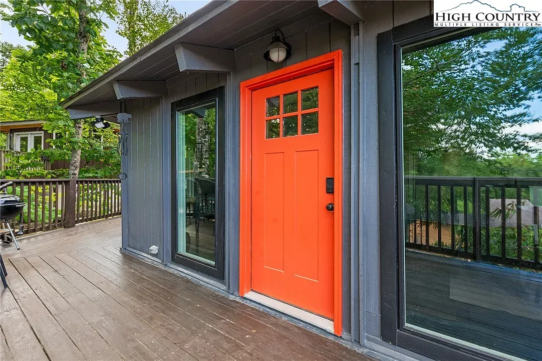 ## That bright orange door pops against charcoal siding—yeah, it’s inviting.