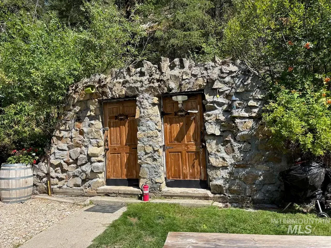 ## Around the bend, a striking stone facade rises—rough-hewn blocks in varied sizes, earthy and honest, blending straight into the landscape.