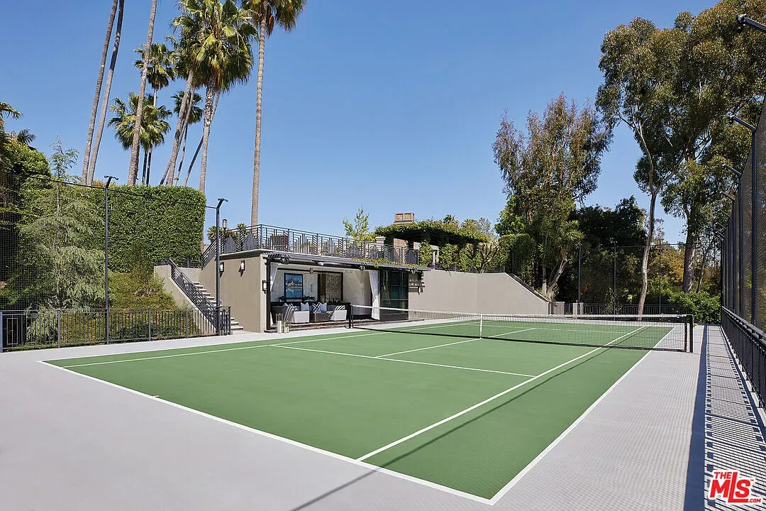 From the baseline, private tennis court framed by palms. Shade breaks between sets, anyone?