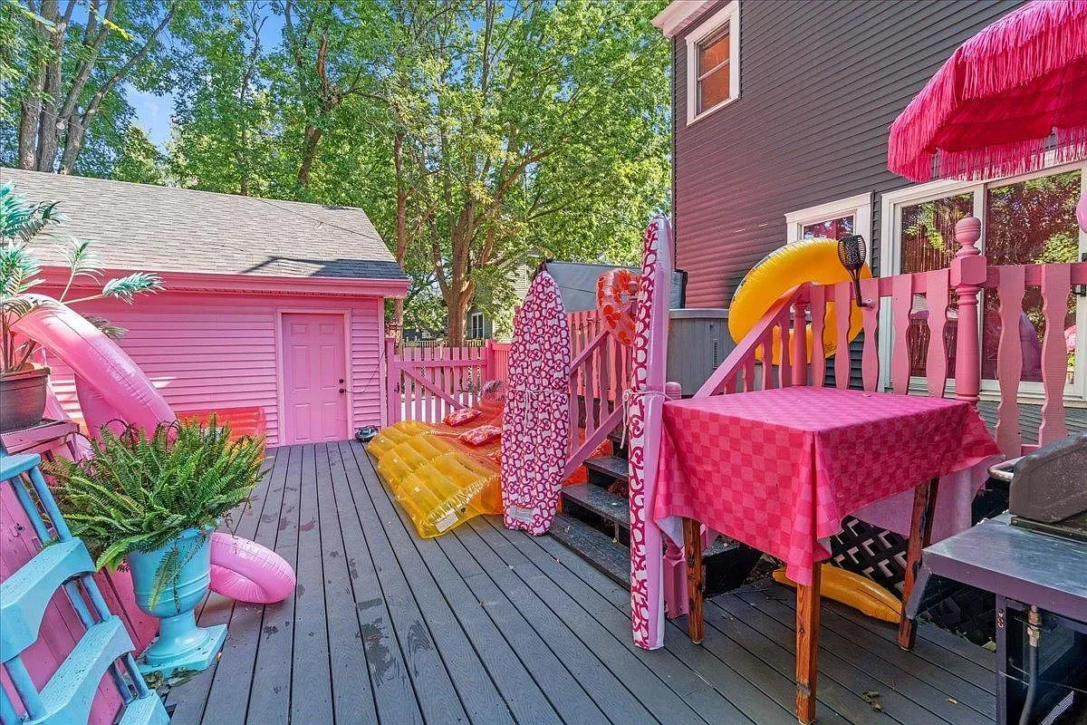 ## Out back, a pink deck spreads out, scattered with bright inflatable pool toys—fun, loud, and perfect for a quick photo before going in.