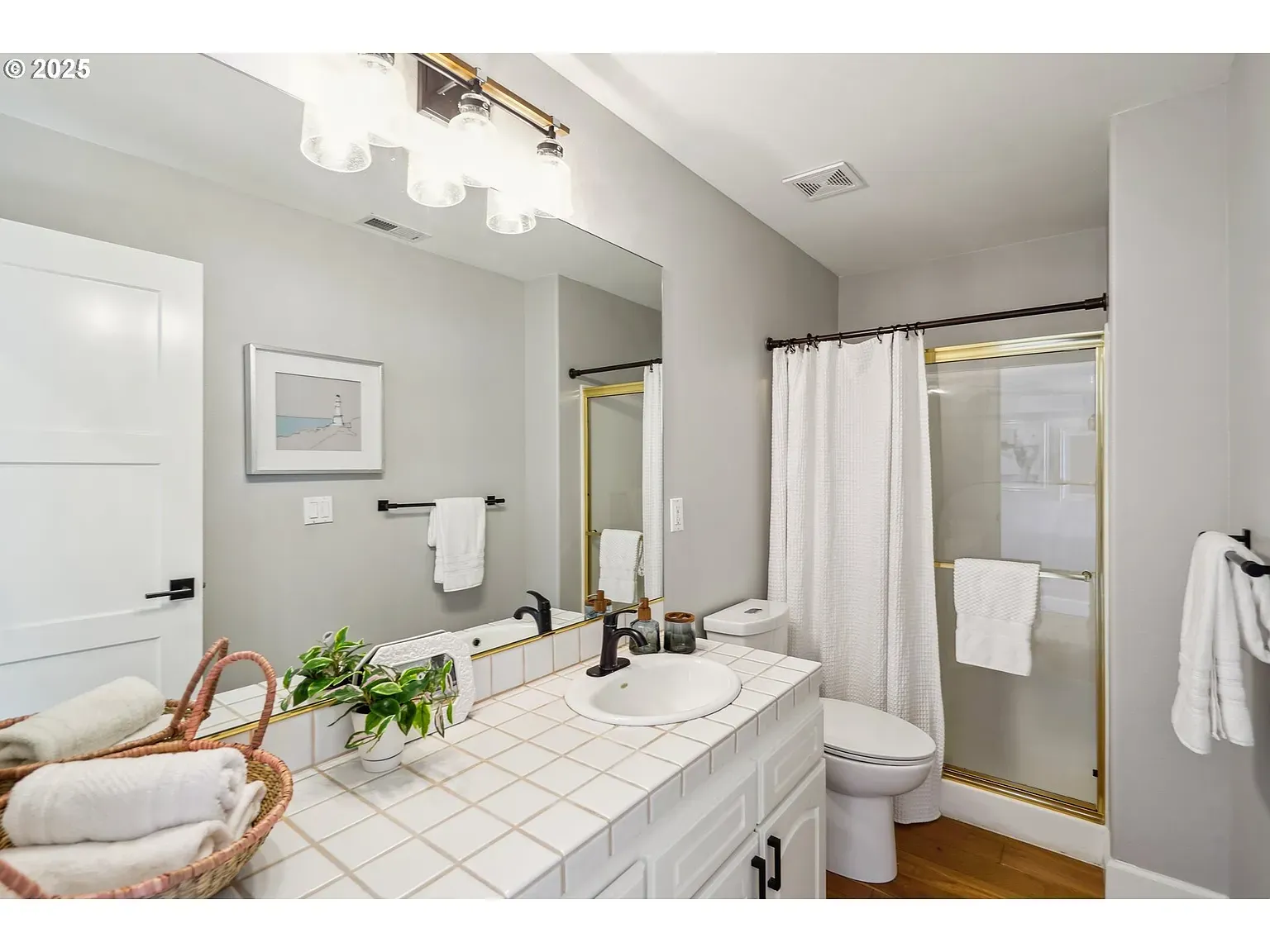 Bathroom goes soft gray and white. Big mirror, oval sink. Safe choice.