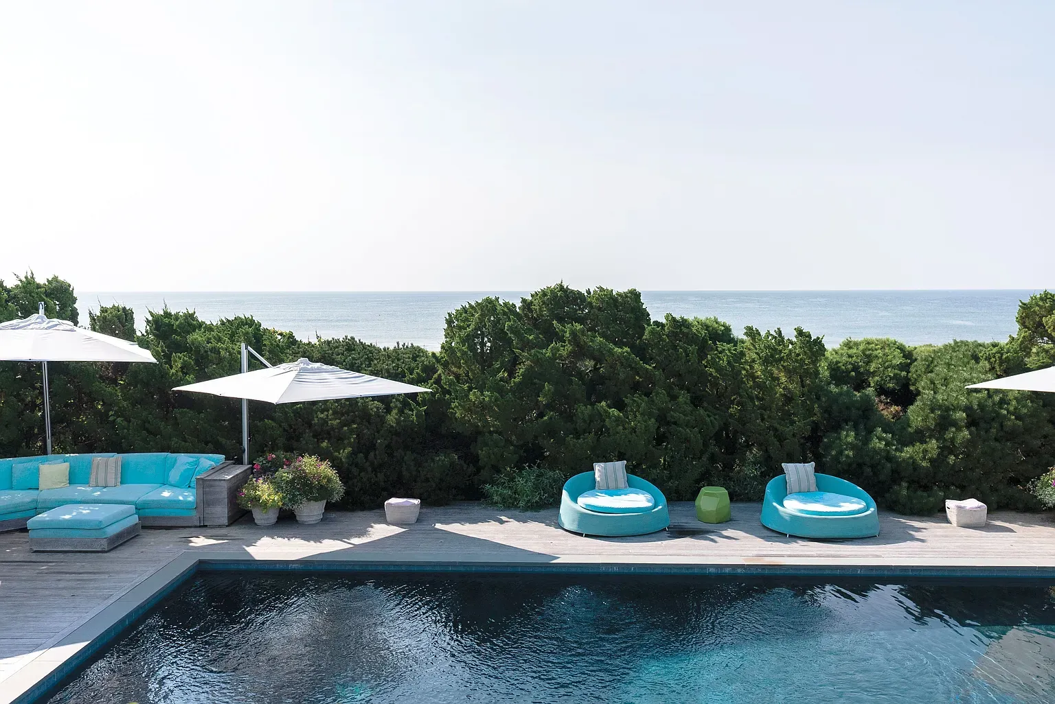 'Just look at this pool area! You’ve got those comfy loungers perfectly positioned for soaking up the sun, and the ocean view is unbeatable. It feels like a little slice of paradise right here!'