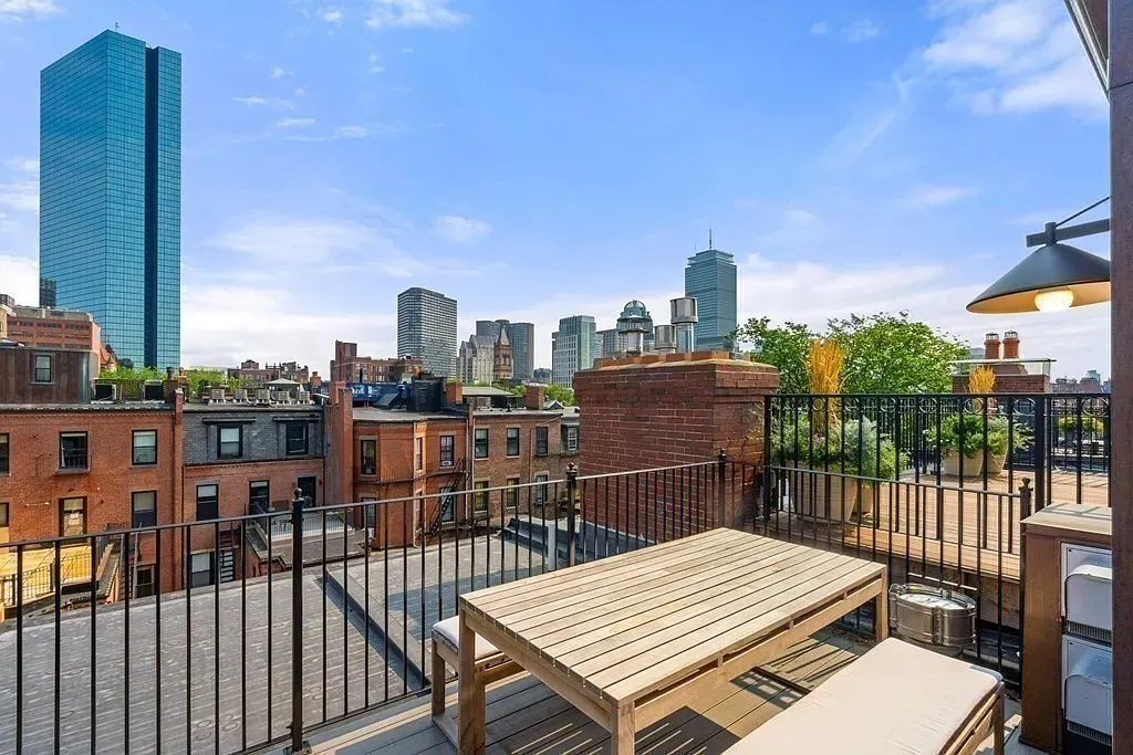 'Look at this rooftop view! You can see the skyline so clearly, and it’s a great spot to hang out or have a meal. The mix of old brick buildings and those sleek towers makes for such a cool backdrop.'