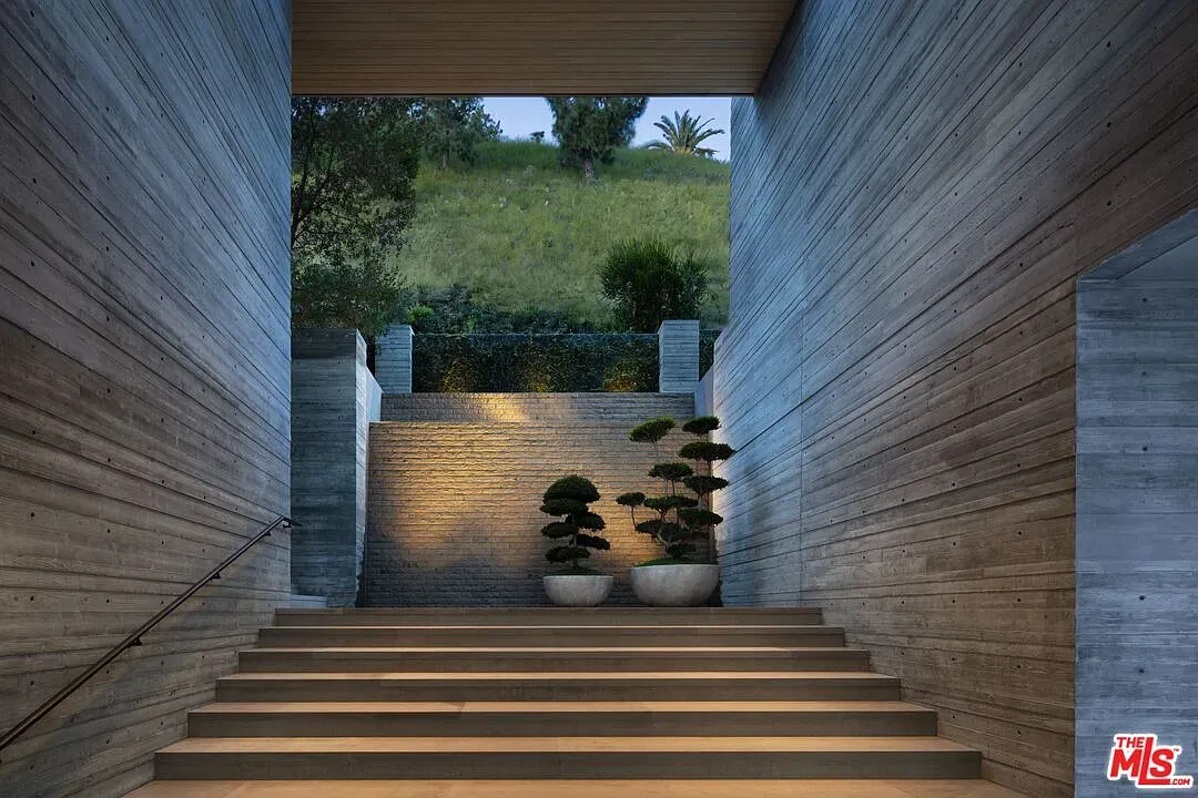 Entrance is brutalist but bright. Concrete canyon opens to trees. Kinda cool.