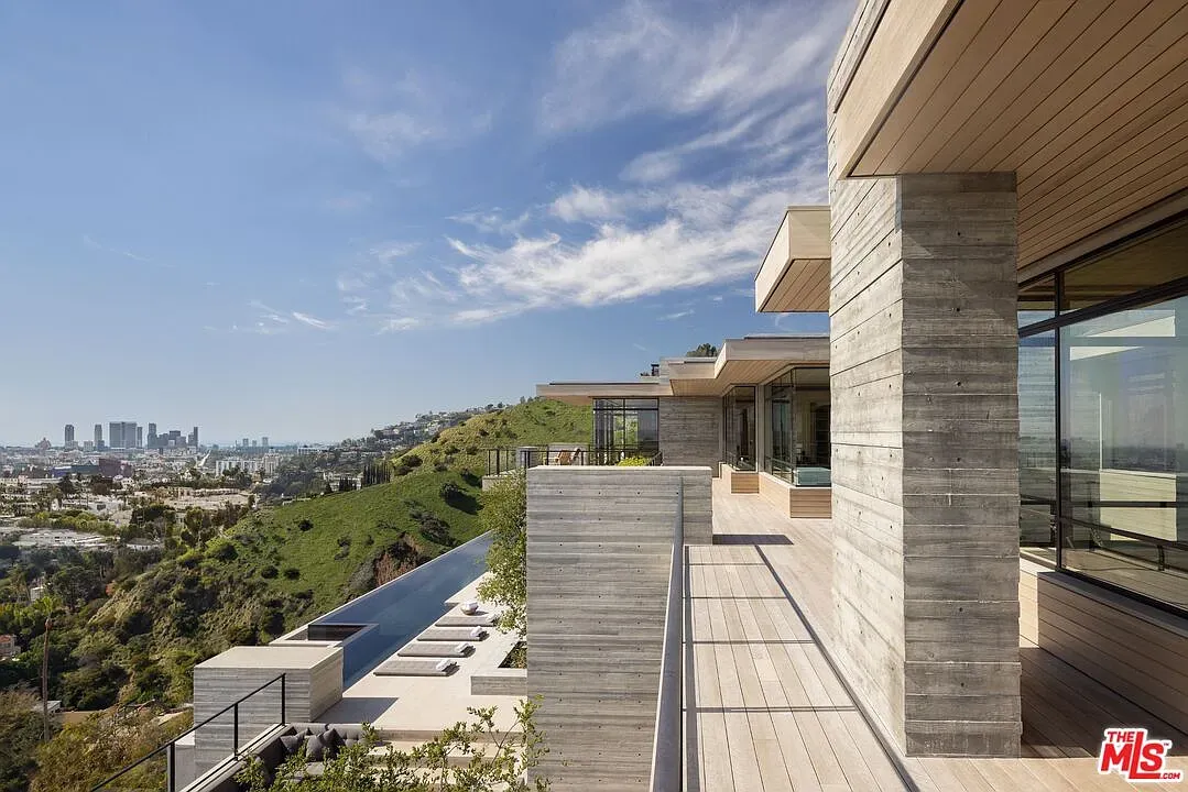 Exterior shot. concrete and glass perched over trees. Terrace view goes forever.