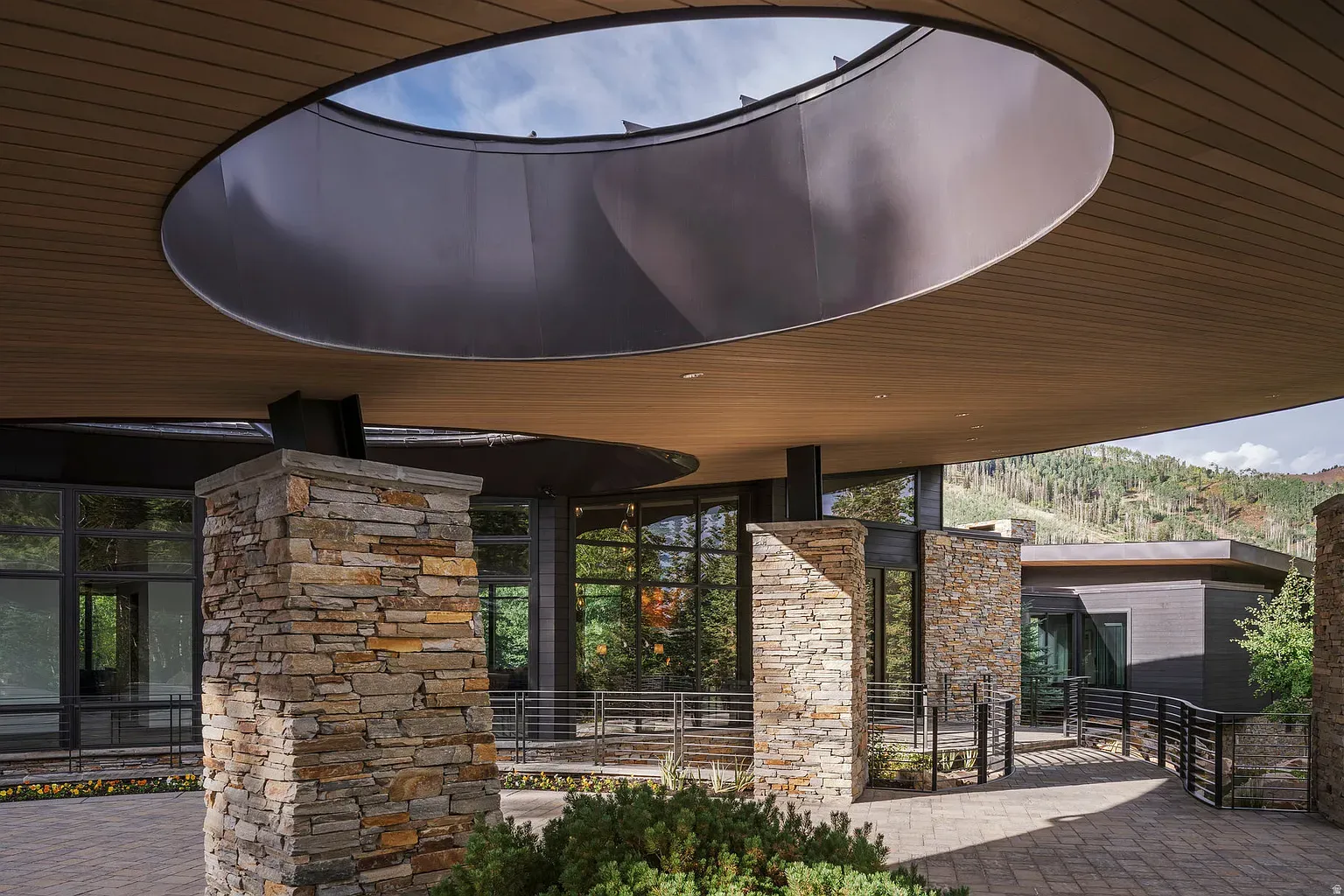 Stone columns plus glass makes the entry look grounded and fancy at once.