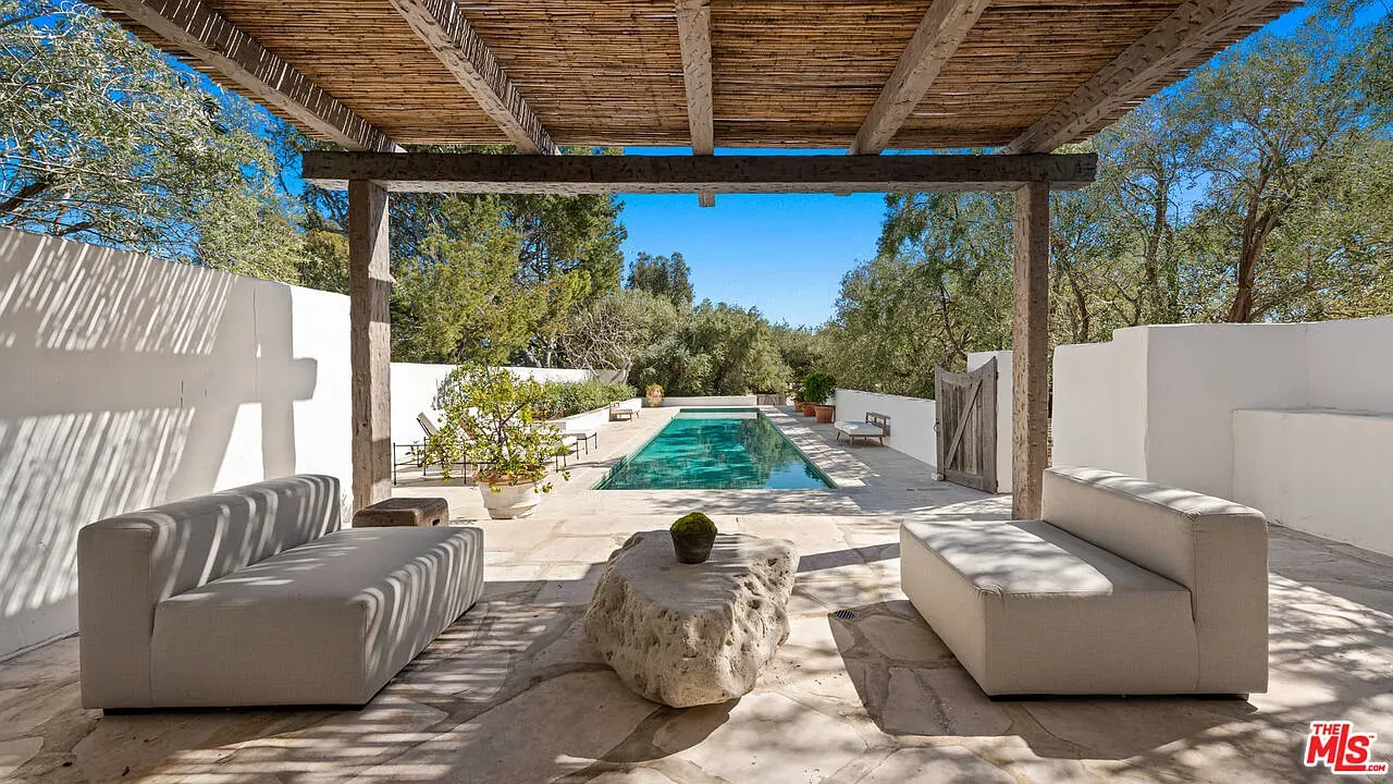 Sleek pool, stone deck. Looks a pergola overhead? Shade goals.