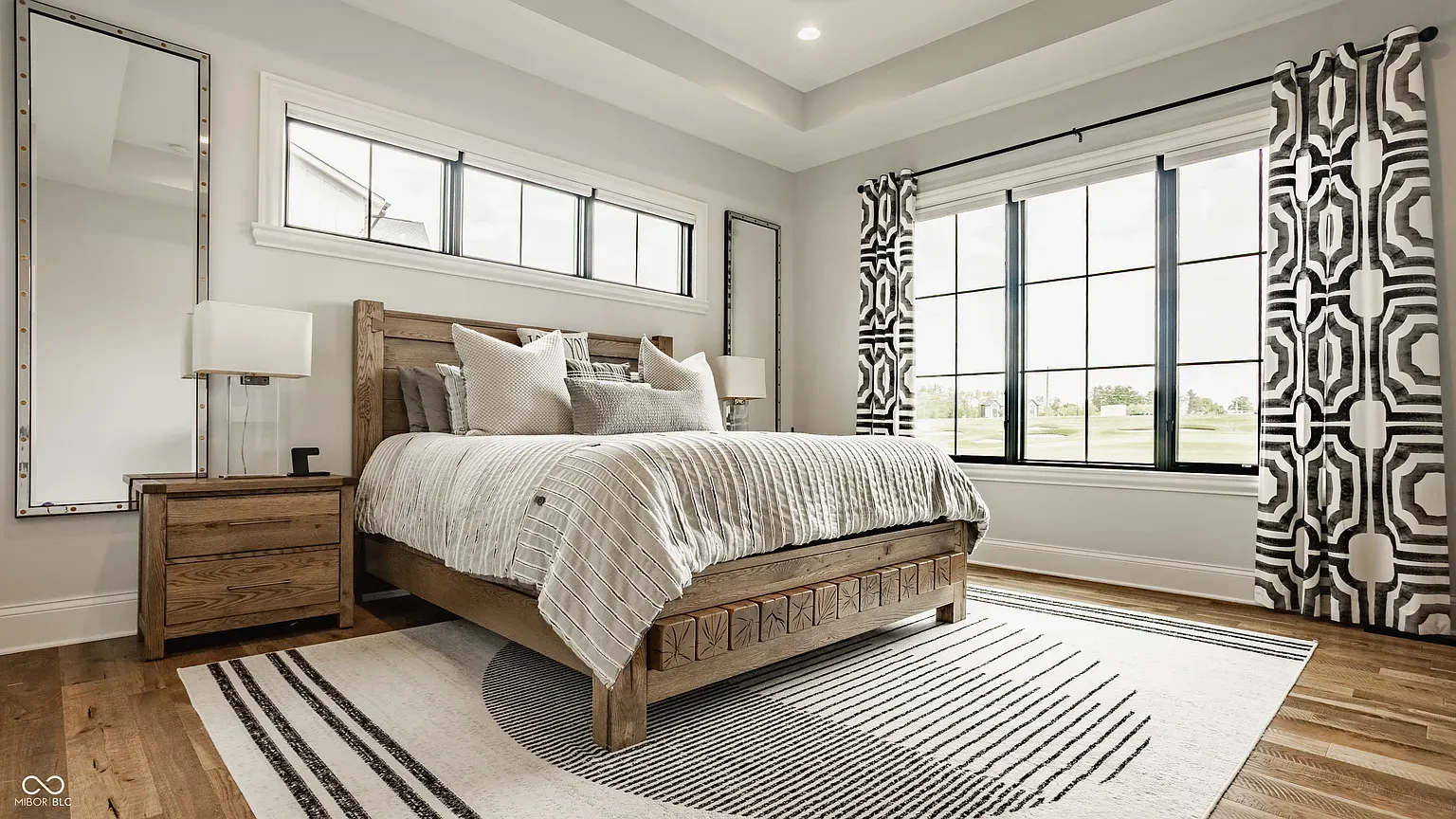 The headboard pattern is doing just enough. Gray bedding keeps it calm.