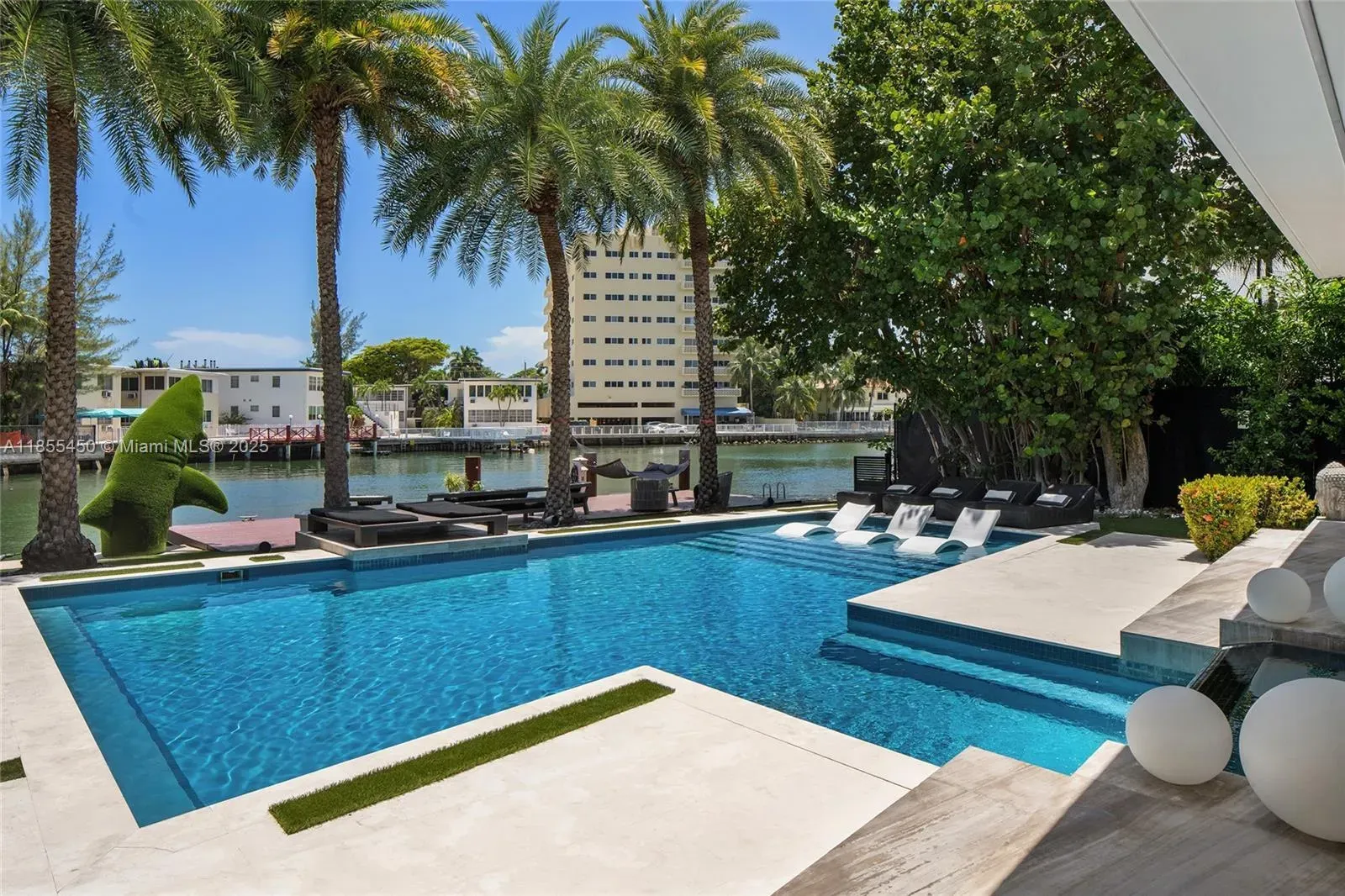 Pool shot—white decking, raised spa, those submerged loungers begging.