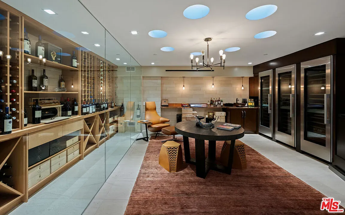 Glass-walled wine lounge. Polished floors, comfy seating, bottles for days.