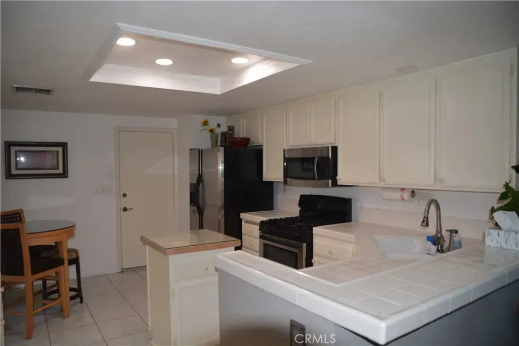 Another kitchen—light cream cabinets, white tile backsplash. Safe choice, or just a bit bland?