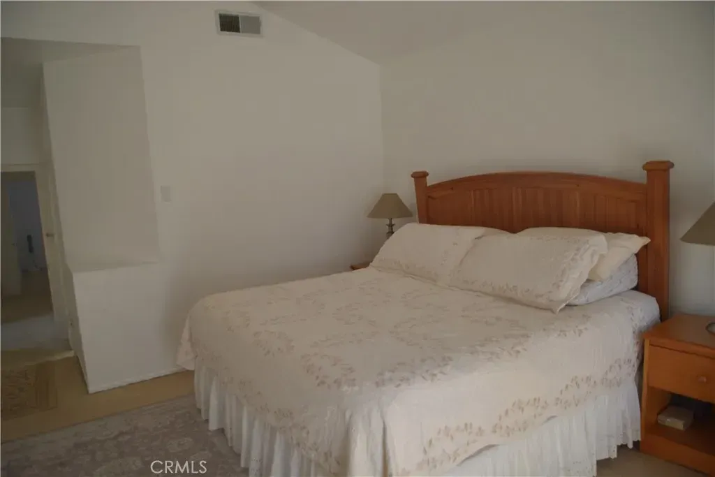 Bedroom calm mode. warm wood, arched headboard, creamy bedding. No clutter. Where’s the closet?