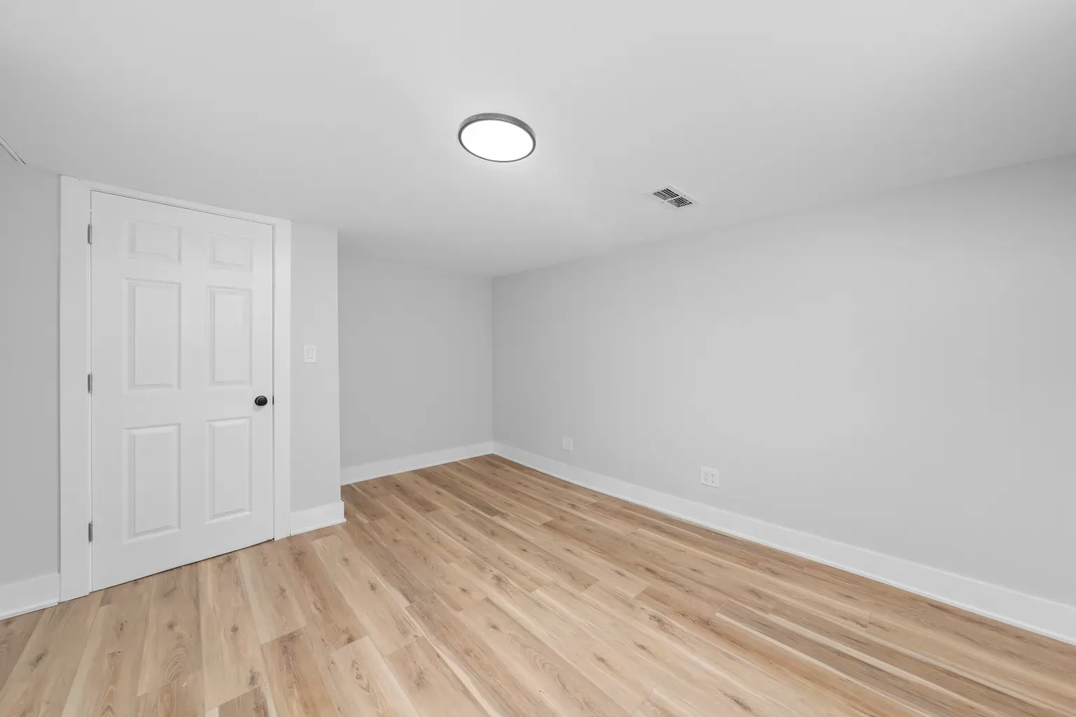 From this angle, gray walls meet warm flooring cleanly. Simple trim, no drama.