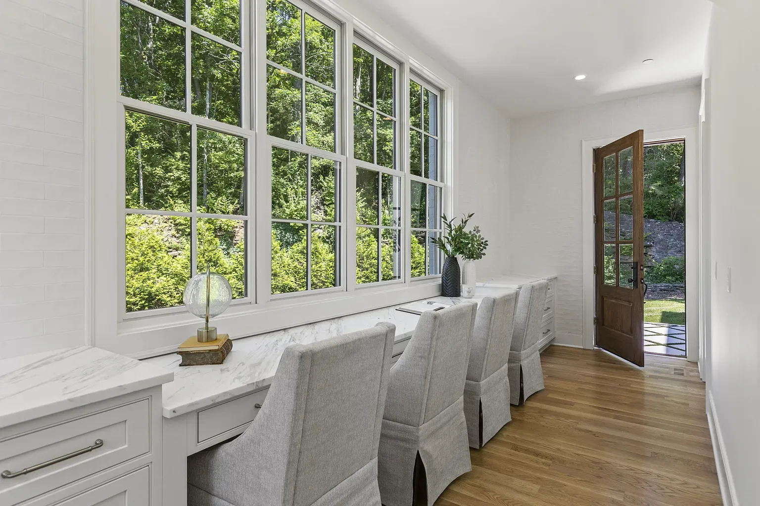 Multi-pane windows framing the trees. Kinda perfect reading corner.