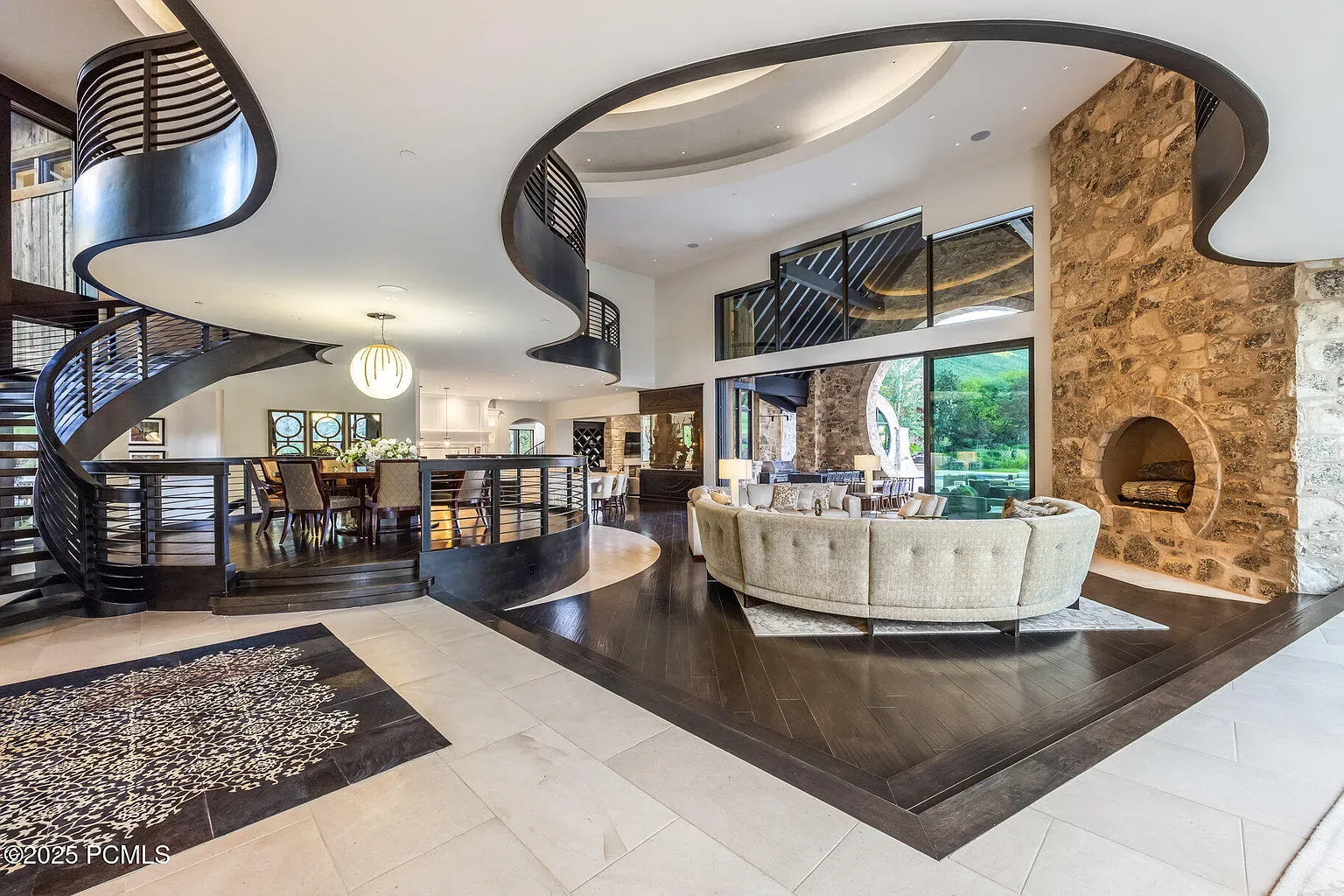 Inside, that spiral staircase steals the show. Black railings, mixed floors.