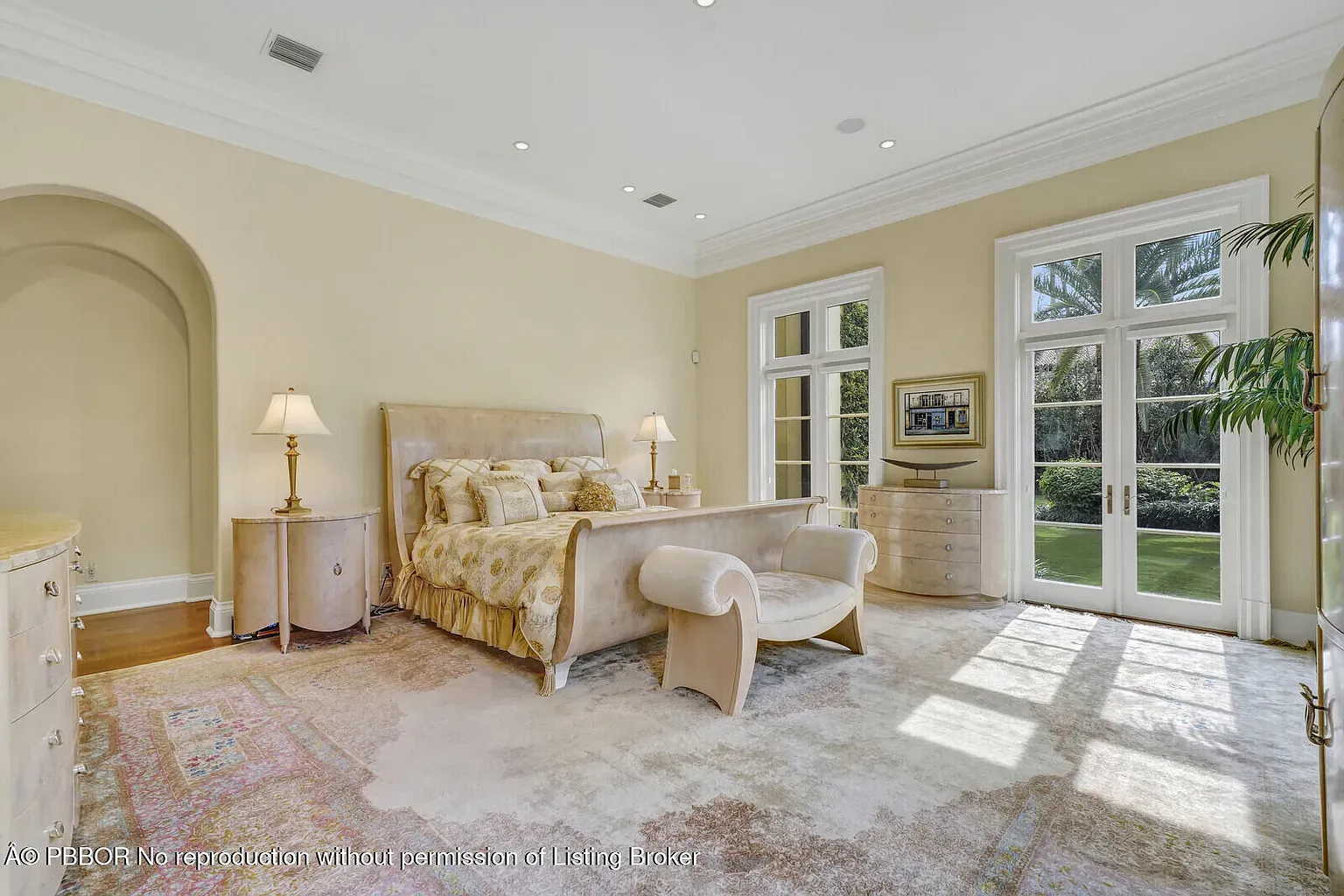 Here's the bedroom — taupe bed, layered pillows, matching lamps. Calm hotel vibes.