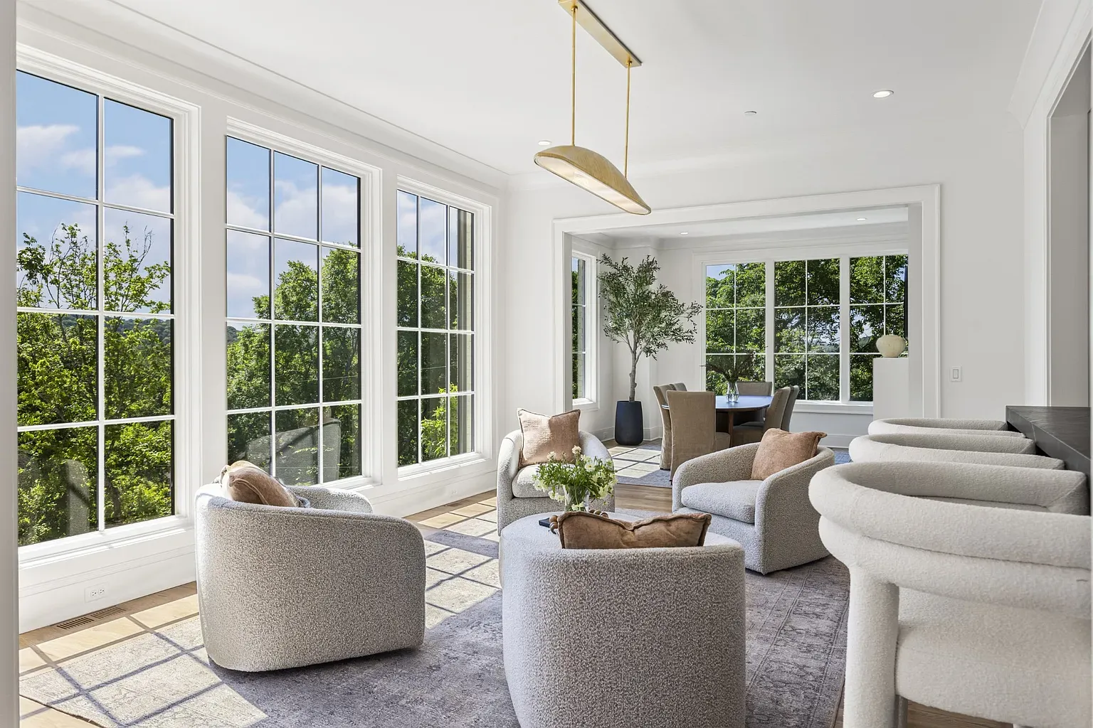 Wall of windows situation. White trim, greenery everywhere.