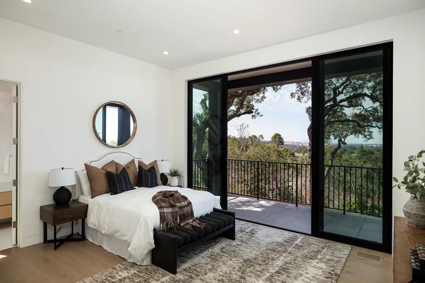 Minimal bedroom with a low black frame and crisp linens. Calm.