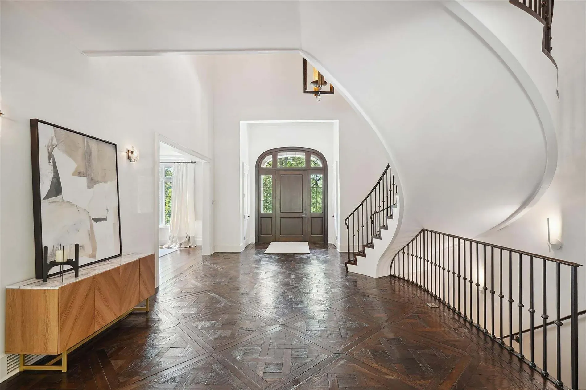 Here's the entry—curved staircase showing off. Railings look custom and pricey.