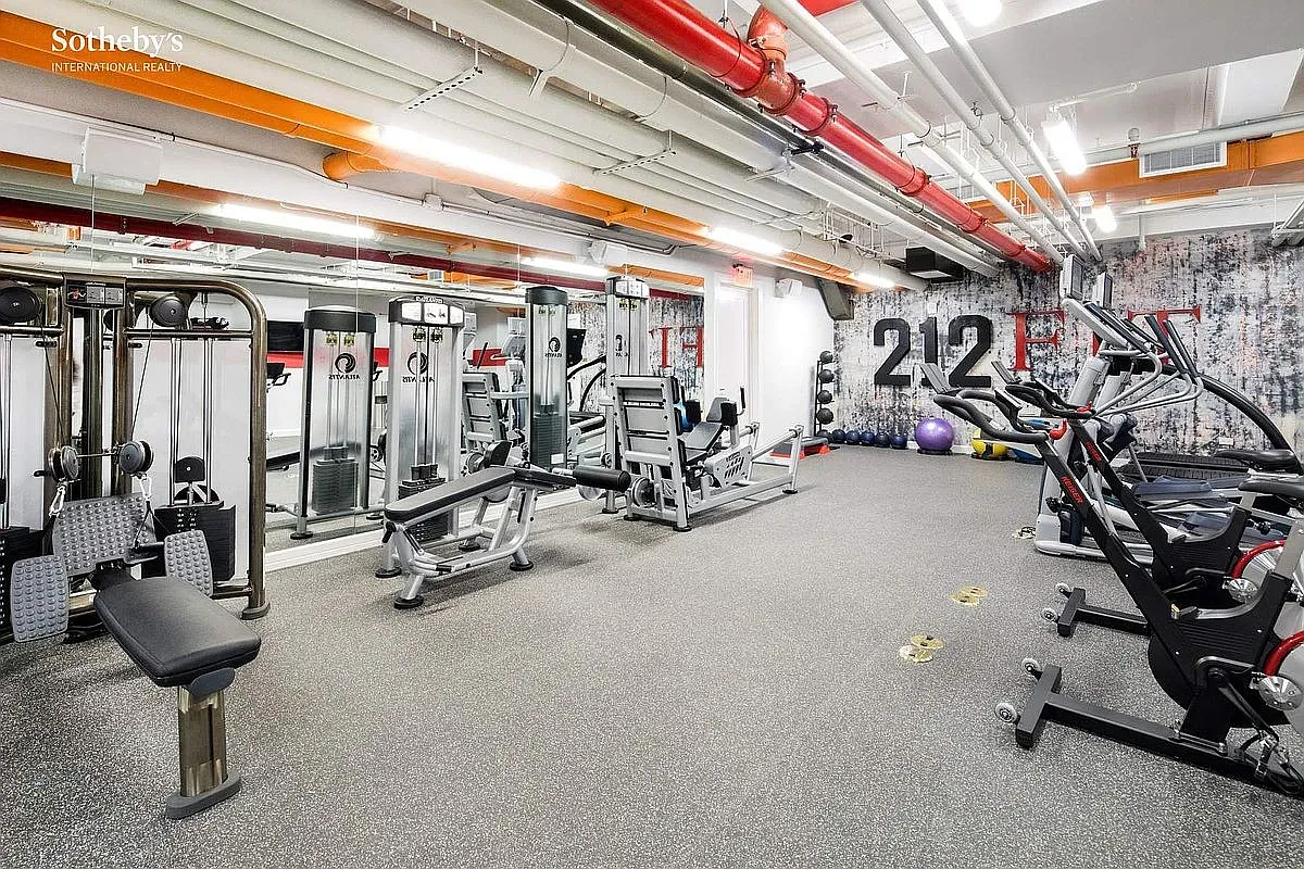 And then the gym — machines lined up, mirrors, pops of color. No excuses zone.